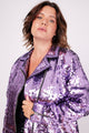Modelo Victoria está usando jaqueta bordada lumi rosa claro. Peça com fechamento de zíper de metal na frente e nos punhos.