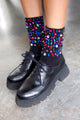 Modelo usa meia bordada candy colorida e sapato preto. Meia ideal para usar no dia a dia e dar um up no look. Feito no Brasil