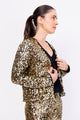 Modelo Simone está vestindo casaqueto luna na cor dourada. Peça super confortável e com muito brilho de paetês bordados à mão