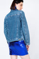 Modelo Juliana usa jaqueta Jeans Bazik azul com uma saia na cor azul. Jaqueta ideal para usar no dia a dia ou em eventos.