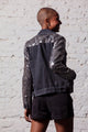 Modelo de costas com jaqueta jeans bordada de brilho com paetês na cor preto e grafite feito à mão para usar no dia a dia