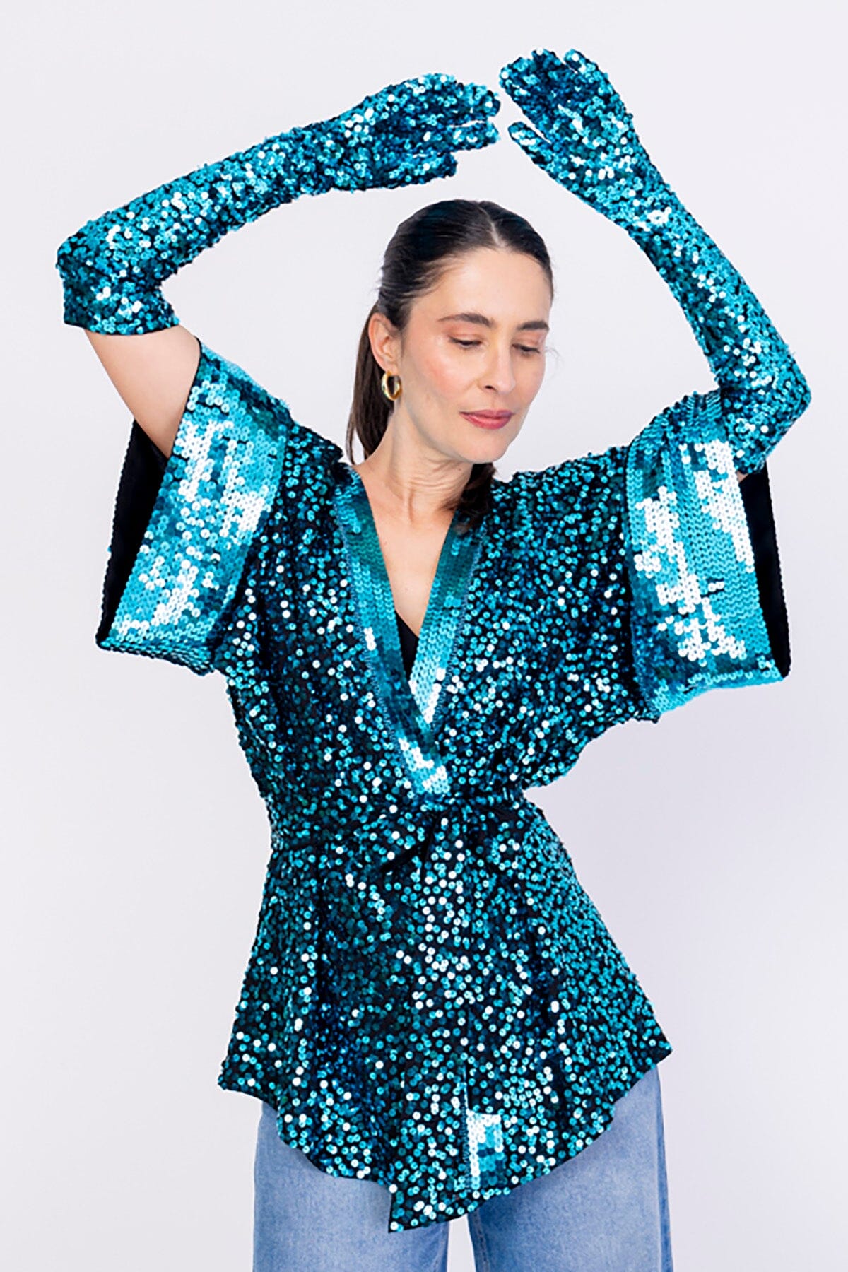 Modelo Simone está usando luva bordada luna cor turquesa e kimono bordado na mesma cor. Acessório com muito brilho de paetês.