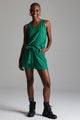 Modelo com a mão no bolso do shorts está usando conjunto Luxor na cor verde. Peça confortável e ideal para usar no dia-a-dia.