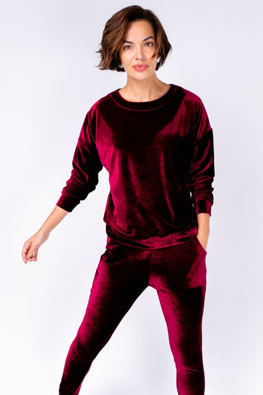 Modelo Michela está vestindo blusa de manga longa Velvet. Peça confortável de tecido de veludo na cor vinho. Feito no Brasil.