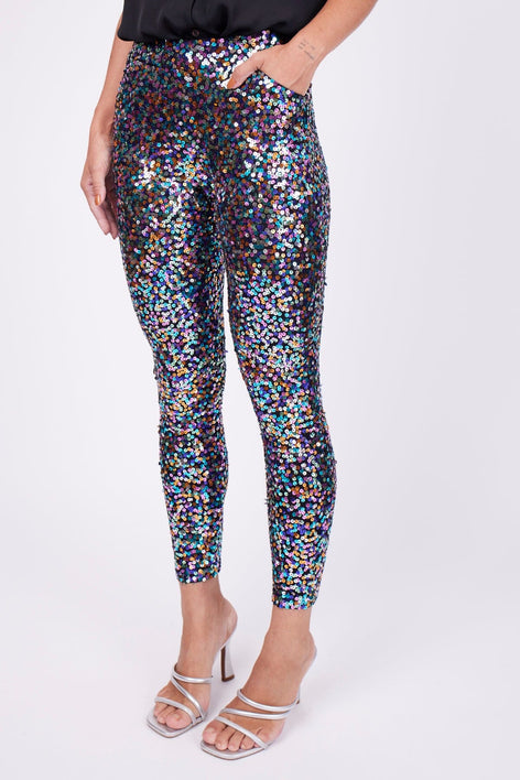 Modelo Marina está vestindo calça bordada luna colorido. Peça com muito brilho de paetês de diversas cores bordados à mão.