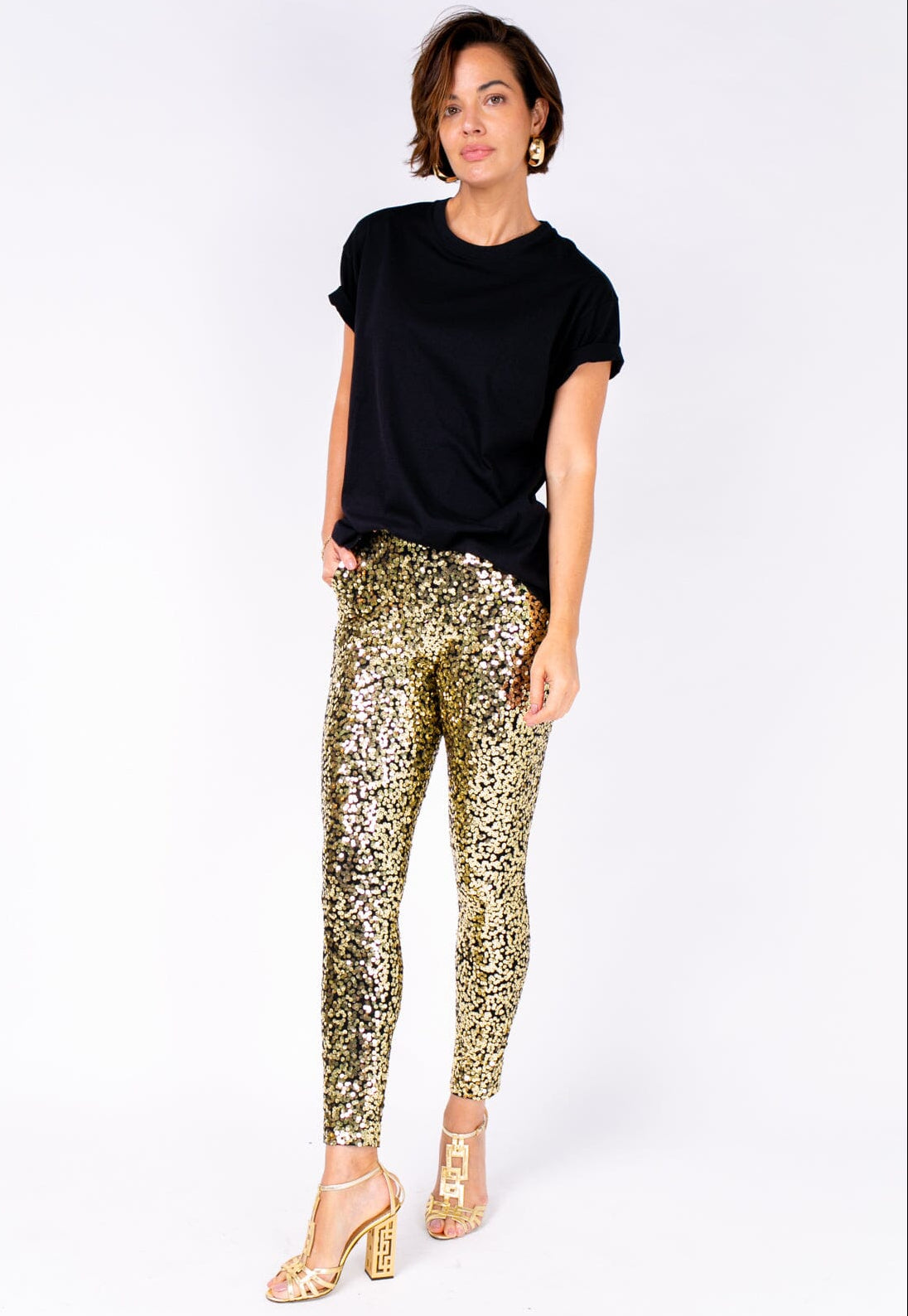 Modelo Michela veste calça luna dourada e blusa na cor preta. Modelo ideal para usar para sair de noite ou ir em eventos.