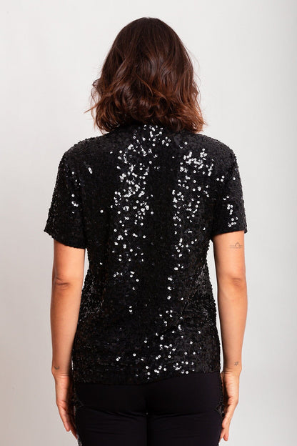 Modelo Victoria está de costas e usando camiseta eris preta. Peça ideal para usar em eventoss especiais, shows ou baladas.