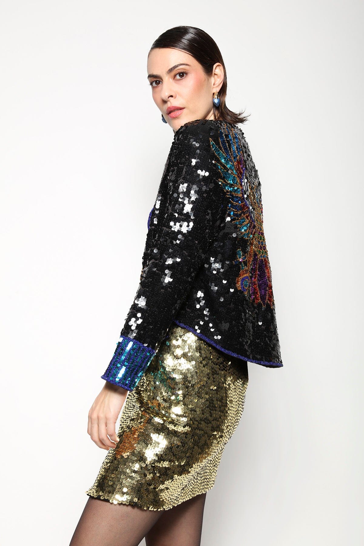 Modelo Isabel veste casaqueto Falcon preto. Peça com bordado manual de paetês que formam desenho de um falcão nas costas.