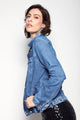 Modelo Isabel usa jaqueta jeans basik azul. Peça possui bolsos nas laterais e bolsos internos, além de fechamento por botões.