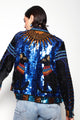 Modelo Isabel está de costas e vestindo jaqueta ailuros azul. Peça com muito briilho de paetês e miçangas bordadas à mão.