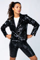 Modelo Nathália está vestindo jaqueta nox. Peça com muito brilho de paetês bordados manualmente na cor preta. Feito no Brasil