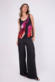 Modelo Marina usa regata bordada Juruá vermelha e pink e pantalona na cor preta. Regata ideal para usar em jantares ou festas