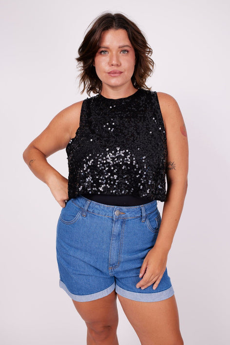 Modelo Victoria está vestindo regata cropped cavada luna preta. Peça cavada, ideal para usar com top, jaqueta e shorts jeans.