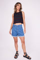 Modelo Marina veste regata cavada spot colorida, shorts jeans e sandálias. Regata ideal para usar em festas ou no dia a dia.