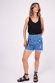 Modelo Marina usa shorts jeans cosmic azul e regata preta. Ideal para usar e arrasar no carnaval ou em festas e passeios.