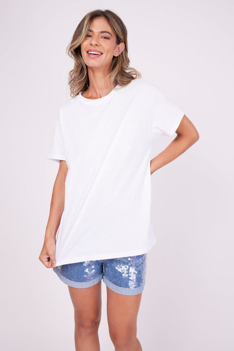 Modelo Maria está usando blusa básica na cor branca. Ideal para usar com calça, shorts, saia ou com sobreposição como jaqueta