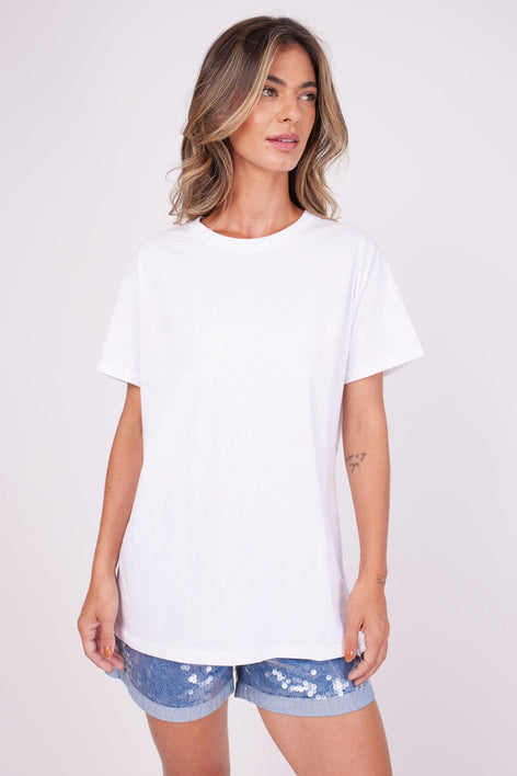 Modelo Marina usa blusa de manga curta na cor branca e shorts. Peça de malha de algodão, é super confortável. Feita no Brasil