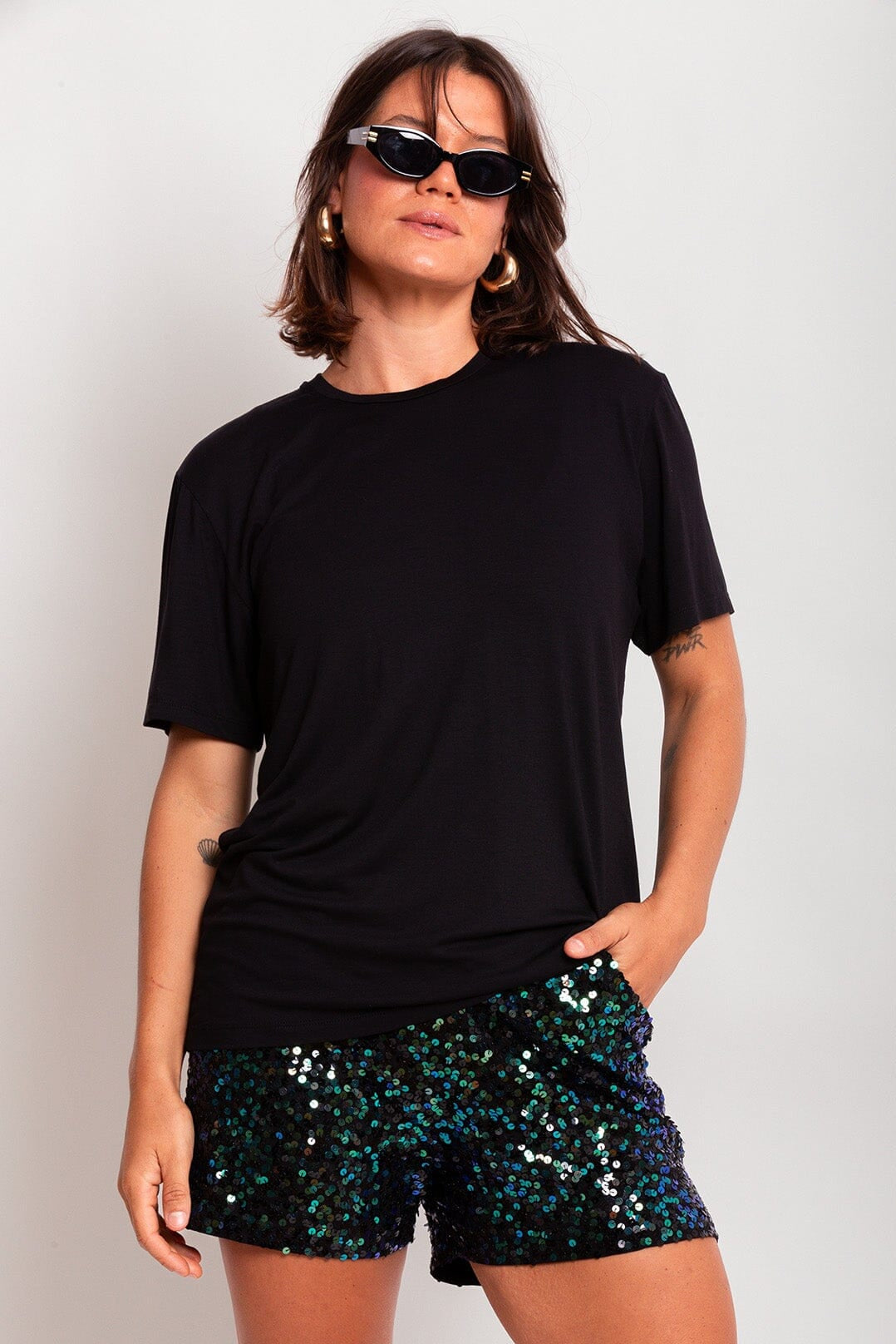 Modelo Victoria está usando camiseta uni na cor preta. Peça de malha super confortável, possui modelagem de manga curta.