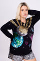 Modelo Visctoria está usando blusa de manga longa planetas preta. Peça feita à mão com muito brilho de paetês de várias cores
