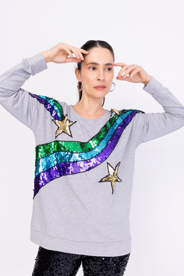 Modelo Simone usa blusa bordada star na cor mescla. Peça com bordada manualmente com paetês que formam desenhos de estrelas.