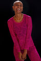 Modelo rindo com blusa Joulik de renda floral tulipa transparente rosa, feito manualmente e ótimo para usar em reveillon