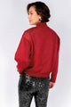 Modelo Michela de costas veste blusa tricot lurex na cor vermelha tamanho P, peça com brilho metalizado ideal para o inverno.