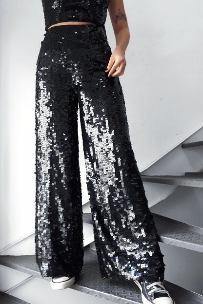 Modelo usa calça pantalona joulik handmade bordada à mão com paetês na cor preto  brilho para usar em festas shows e eventos 