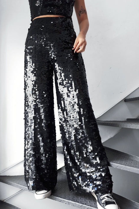 Modelo usa calça pantalona joulik handmade bordada à mão com paetês na cor preto  brilho para usar em festas shows e eventos 