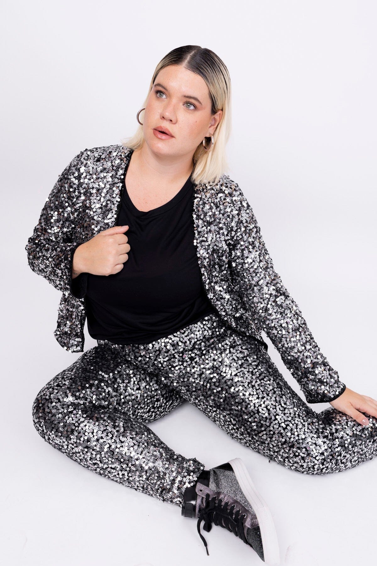 Modelo Victoria está usando calça bordada luna grafite com prata, casaqueto luna grafite com prata e blusa básica cor preta.