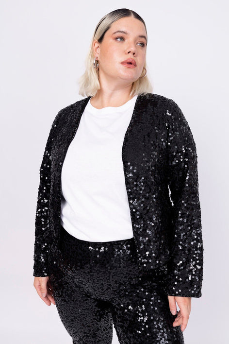 Modelo Victoria usa casaqueto luna e blusa branca. Peça com bordado salpicado feito à mão com paetês e vidrilho na cor preta.