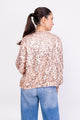 Modelo Simone está de costas e usa jaqueta bordada bomber eris rosé. Peça ideal para compor looks e usar em diversos locais.