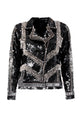 Foto em estilo still da jaqueta perfecto bordada kim preta. Peça possui fechamento frontal e nos punhos com zíper de metal.