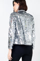 Modelo Juliana Bernardino está de costas e usa jaqueta perfecto lumi na cor prata. Peça com muito brilho de paetês bordados.