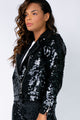 Modelo Nathália está vestindo jaqueta nox na cor preta. Peça possui fechamento de zíper de metal na frente e nos punhos.