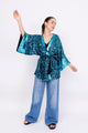 Modelo Simone está vestindo kimono eris turquesa, luva bordada luna turquesa e calça jeans. Kimono com muito brilho de paetês
