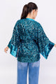 Modelo Simone está de costas e veste kimono eris turquesa. Peça com bordado manual. Ideal para usar em eventos especiais.