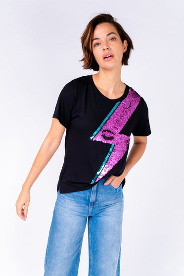 Modelo Michela está vestindo camiseta bordada à mão com paetês colorido, possui desenho raio bowie handmade na blusa preto.