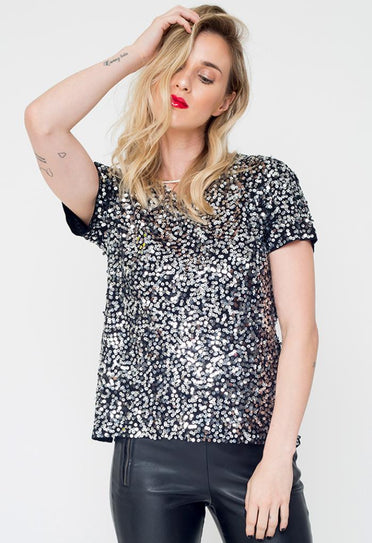 Modelo Juliana está vestindo camiseta bordada luna. Peça com muito brilho de paetês salpicados nas cores prata com grafite.