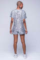 Modelo Fernanda está de costas e usa blusa bordada luna na cor prata. Ideal para ir em eventos, passeios, jantares ou baladas