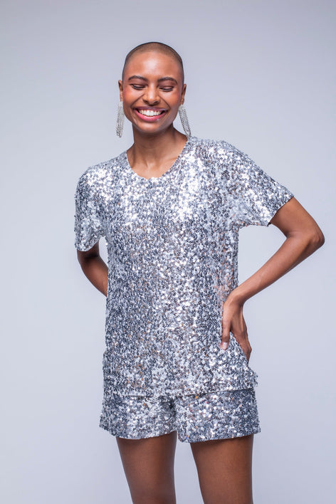 Modelo Fernanda está usando blusa bordada luna. Peça de malha com muito brilho de paetês na cor prata bordados manualmente.