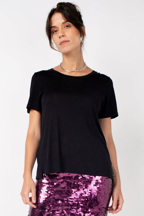 Modelo Nat usa tshirt básica cad em tecido malha na cor preta. Peça com manga curta, decote redondo e modelagem mais soltinha