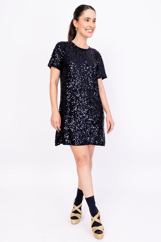 Modelo Simone usa vestido bordado luna. Peça super confortável de malha, possui bordado salpicado de paetês na cor preta.