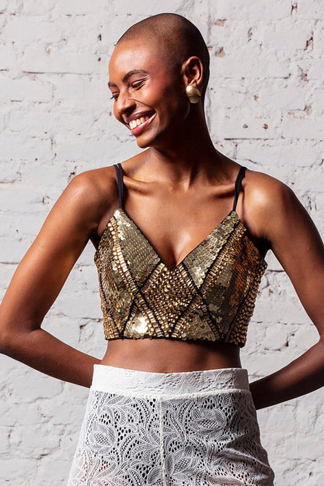 Modelo veste top Joulik bordado à mão handmade com paetês e pedrarias na cor dourado e preto brilho para festas e shows