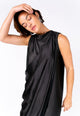 Modelo Michela está vestindo vestido sonia. Peça com tecido acetinado na cor preta, é um modelo ideal para usar com sandálias