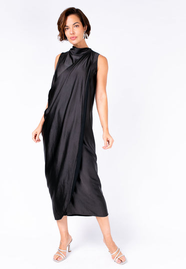 Modelo Michela está vestindo vestido longo Sonia na cor preta. Peça com tecido acetinado, ideal para usar em festas e eventos