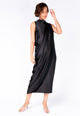 Modelo Michela usa vestido longo sonia preto. Peça com fechamento lateral de botão, feito de tecido em acabamento acetinado.